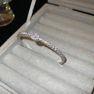 Macro shot of silver plated oval bracelet with pavé cubic zirconia on grey velvet