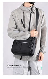 Close-up of black multi-pocket messenger bag featuring a durable strap and D-ring detail