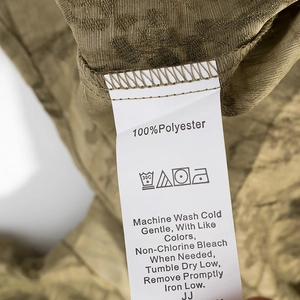 Close-up of garment care label on jacquard fabric showing 100% polyester composition