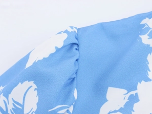 Detail der Puffärmel-Schulternaht an einem hellblauen Maxikleid mit Blumenmuster