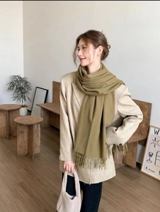 Olive green cashmere-feel scarf with fringes styled over a beige blazer suit