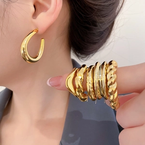 Detailed view of textured gold hoop earrings featuring braided and wavy patterns