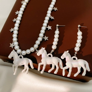 Star and horse pearl necklace and earrings set on premium brown leather background