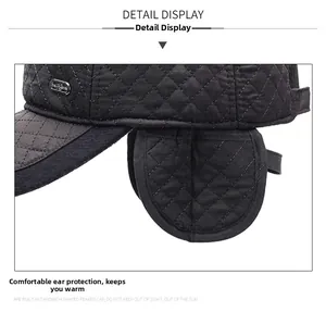 Dettaglio del cappello invernale trapuntato nero con paraorecchie e decoro in metallo