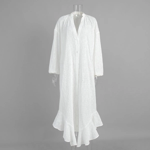 Close-up of white summer dress featuring eyelet embroidery and ruffle hem details