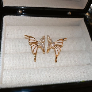 Macro d'oreilles papillon en or avec émail blanc et oxydes de zirconium brillants