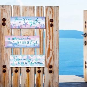 Detail of wooden mermaid plaques with ocean quotes on a vintage door with sea background