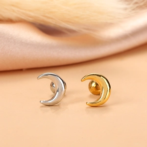 Detailed view of silver and gold moon cartilage studs with screw back design