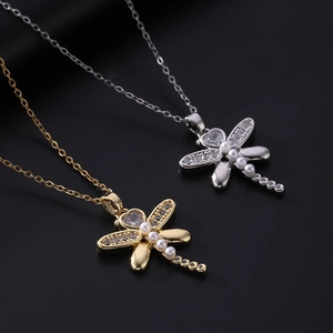Detailed view of dragonfly pendants in gold and silver with zircon and pearls
