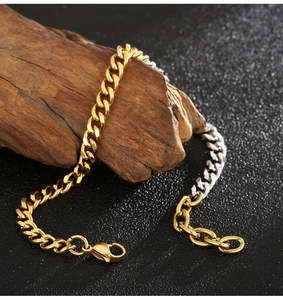 Detailed close-up of mixed gold and silver Cuban chain bracelet on dark wood
