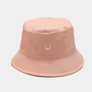 Close-up of the smiley face embroidery and stitching on the pink cotton bucket hat