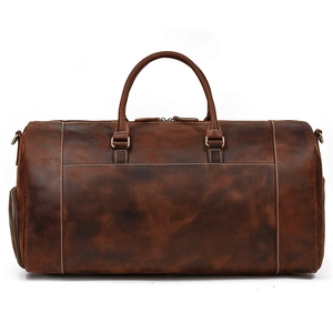 Detail view of vintage brown leather duffel bag with bronze hardware and side pocket