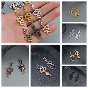Detailed view of snake-shaped jewelry pendants in multiple metallic plated finishes