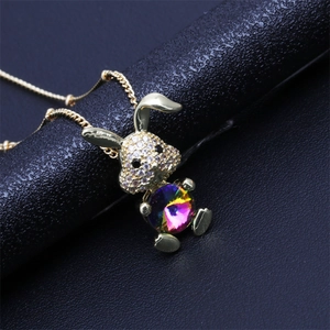 Detail of a rabbit pendant featuring colorful faceted crystal and pavé stones on a gold chain