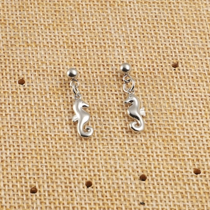 Paire de boucles d'oreilles hippocampe argentées sur toile de jute au design marin