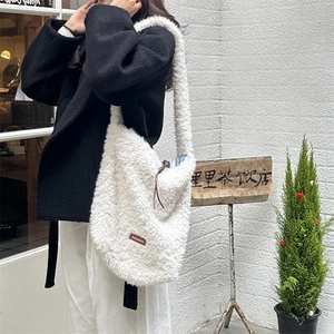 Close-up of fluffy white lamb wool tote bag featuring a brown logo tag on a shoulder strap