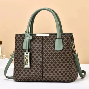 Close-up of geometric pattern printed handbag with morandi green leather handle and gold hardware