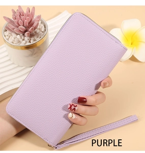 Close-up of purple long zip wallet featuring litchi texture and matching wristlet strap