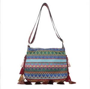 Ethnic woven crossbody bag with colorful geometric patterns and decorative tassels