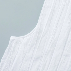 Gros plan détaillé sur le tissu blanc plissé d'une robe d'été courte sans manches