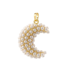 Macro detail of crescent moon pendant with gold base and white inlaid pearls