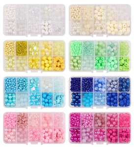 Eight plastic storage boxes with various macaron glass beads in round and star shapes