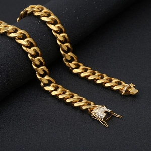 Macro shot of gold-plated Cuban link chain featuring a sparkling diamond-set square clasp