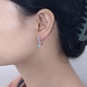 Elegant S925 sterling silver hoop earrings with teardrop turquoise stones on model