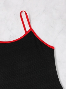 Detail of black wave texture fabric and red piping on backless one-piece swimsuit