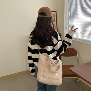 Large beige fleece tote bag shown with casual autumn knitwear and corduroy cap