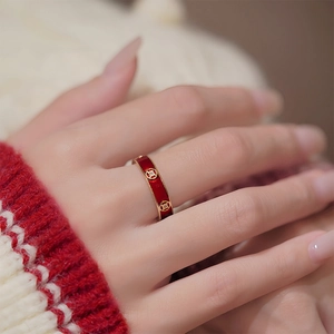 18k gold plated open ring with red enamel and coin motifs on white knit background
