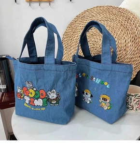 Detail of blue denim tote bags with cute cartoon embroidery and daily life scene