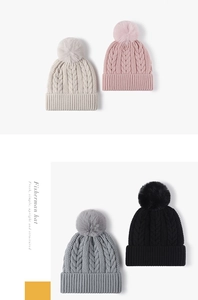 Detalle de cuatro gorros de punto jacquard con pompones en blanco, rosa, gris y negro
