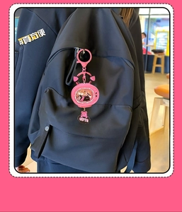 Pink cat TV keychain with flowing glitter and cute cat paw pendant on a black backpack