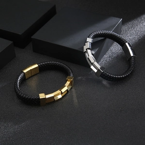 Detail of black braided leather bracelets with gold and silver magnetic metal clasps
