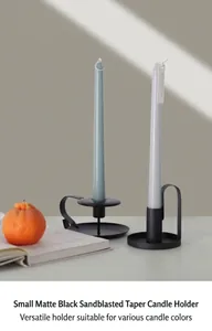 Detail of matte black wrought iron candle holders with Nordic minimalist design and sandblasted finish