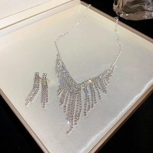 Close-up of sparkling rhinestone tassel necklace and earrings set in a premium jewelry box
