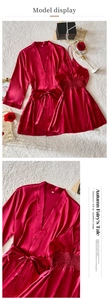 Vue à plat du peignoir en satin rouge foncé et nuisette en dentelle sur tapis peluche