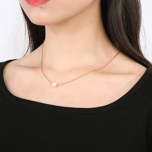 Minimalistische goldene Schlüsselbeinkette mit runder weißer Perle am Model
