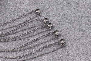 Détail de plusieurs chaînes en acier titane avec fermoirs mousqueton pour colliers