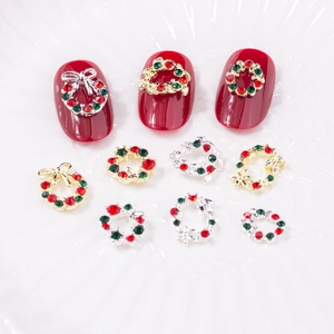 Détail de bijoux d'ongles de Noël avec couronnes festives et nœuds rouges et verts