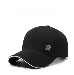 Detailed close-up of a black baseball cap with white trim and a golden metallic badge