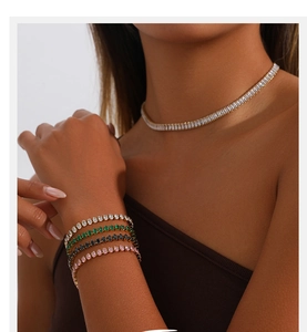 Détail de colliers tennis et de bracelets en zircon blancs, verts et roses étincelants