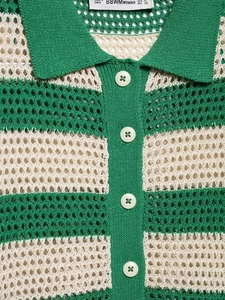 Detail eines grün-beige gestreiften Poloshirts mit weißen Knöpfen und Strickkragen-Textur