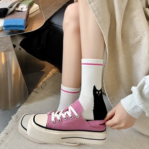 Detail of white cotton crew socks with black cat illustration and pink stripes on a model