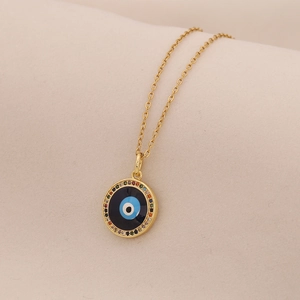Macro shot of gold necklace featuring a blue evil eye pendant with colorful gemstones