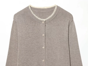 Close-up of elegant taupe knit cardigan featuring delicate white lace trim on the neckline