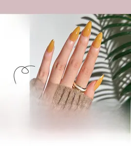 Close-up of almond mustard yellow gradient press-on nails with fine gold glitter tips