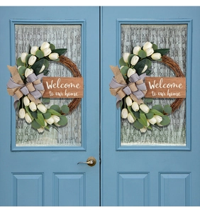 Detail of tulip wreath featuring burlap bow and Welcome to our home wooden sign decoration