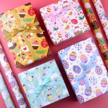 Flat lay of Happy Easter wrapping paper and gift boxes with bunny and egg patterns